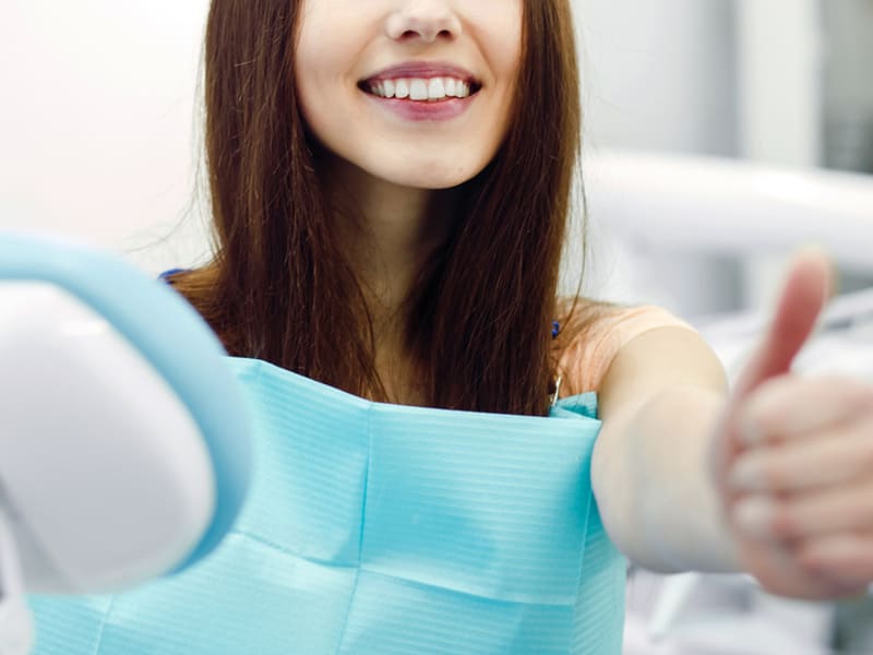 笑顔で歯科健診を受ける女性の画像
